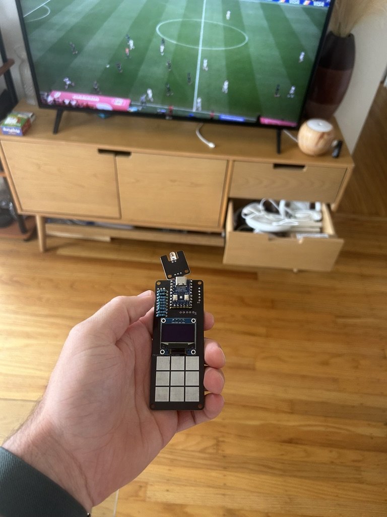 Custom touch remote held in front of a TV